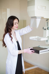 年轻开朗的乳房专家站在室的乳房超声检查仪器附近的侧视图