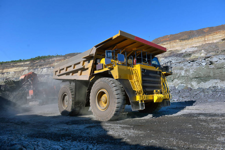 把煤装进车身工作卡车. 采矿车采矿机械从露天矿运输煤炭照片