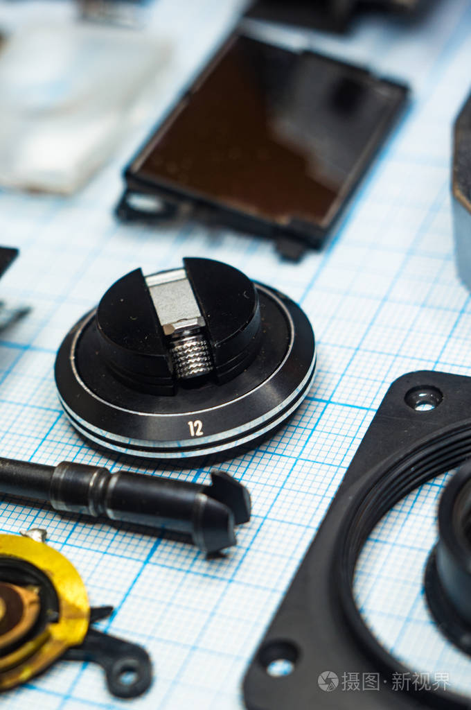 零件完全拆卸旧的复古胶片slr相机在图纸上关闭