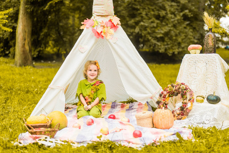 s house wigwam in park Autumn portrait of cute curly girl. Harve