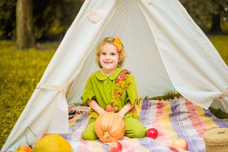 s house wigwam in park Autumn portrait of cute curly girl. Harve