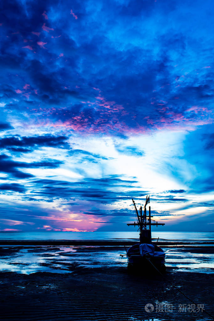 清晨的阳光照耀着大海,船在海滩上.