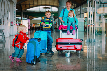 家庭旅行母亲与孩子和手提箱在机场
