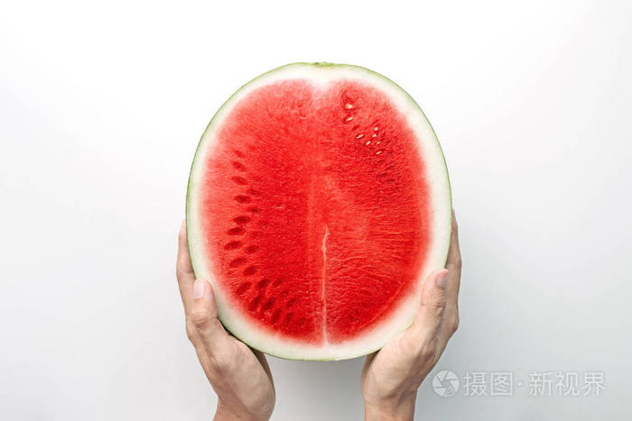 双手捧着半个红色西瓜在白色背景的顶部视图与剪裁路径