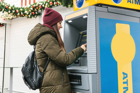 一个年轻女人从 Atm 机里拿钱