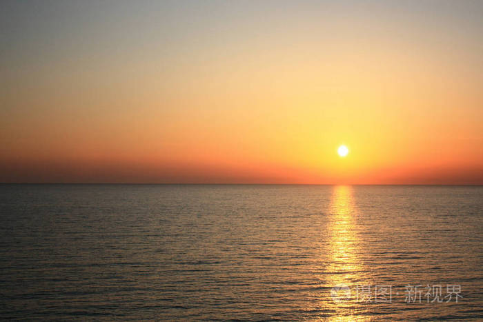 橙色的太阳. 夏天温暖的夜景从悬崖到大海.