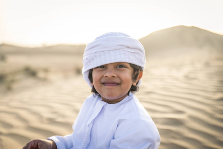 快乐的家庭在迪拜沙漠玩耍嬉戏的父亲和儿子在户外玩得很开心