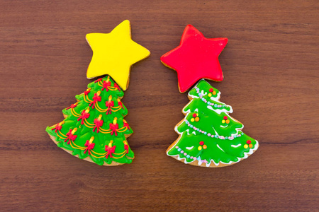 圣诞饼干的形状是圣诞树和星星。 木制桌子上美味的姜饼。 顶部视图