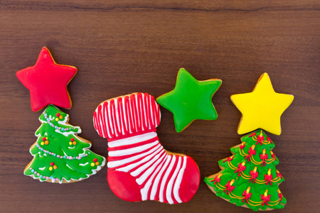 圣诞饼干的形状是圣诞树明星和圣诞袜子。 木制桌子上美味的姜饼。 顶部视图