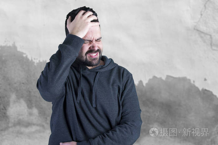 白种人害怕站在灰色的墙壁上闭着眼睛手牵着头