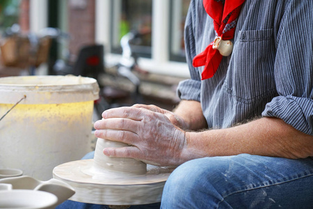 s hands make a clay pitcher, macro. Potter makes a pitcher.