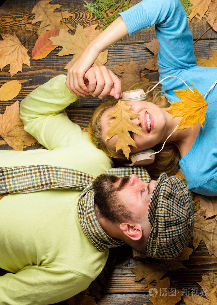 听音乐耳机躺在木质背景的顶部视图相爱的情侣享受秋天的温馨季节秋季