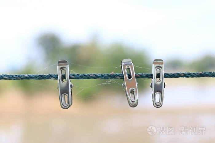 在模糊背景特写上隔离的绳子上的晾衣绳金属晾衣绳。