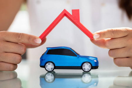 s Hand Holding Roof Over Blue Car