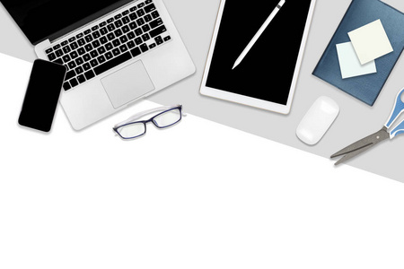 办公桌的平躺照片，配有笔记本电脑数字平板手机和配件。 现代两种色调白色和灰色背景。 桌面办公室模型概念。