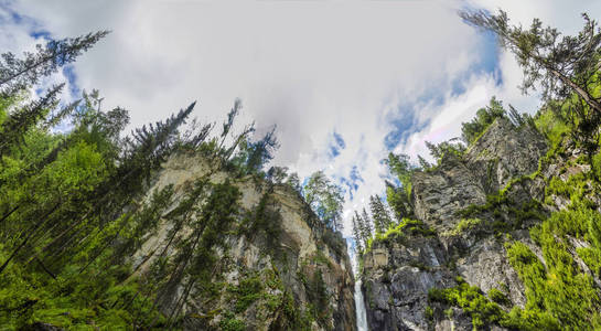 一条山溪和一条瀑布的全景和风景，在野生森林和雄伟的岩石。 阿尔泰西伯利亚俄罗斯。 白天是轻夏。
