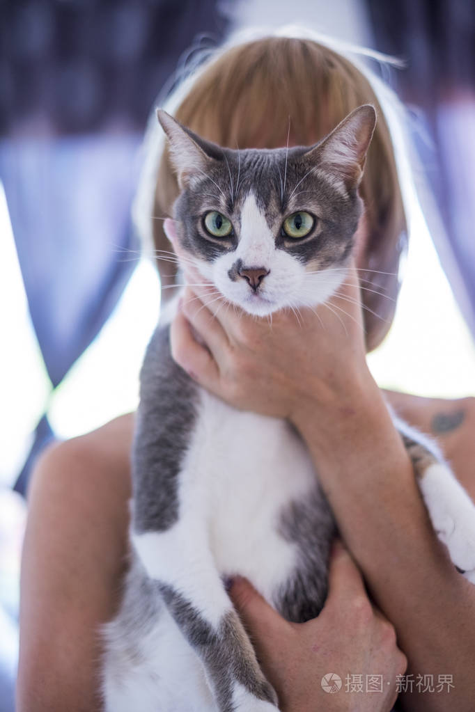 女人把猫抱在头前