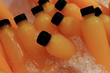 在市场街食品的冷藏瓶中新鲜的橙汁选择性聚焦