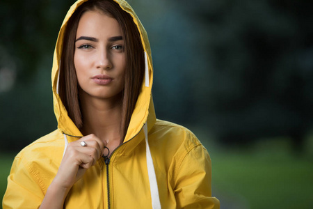 女人穿黄色雨衣带帽子公园