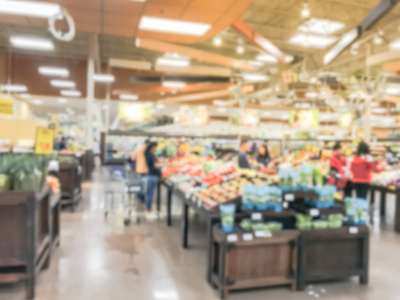 模糊的运动繁忙的客户购物新鲜水果和蔬菜在欧文德克萨斯美国杂货店。 有机本地生长的产品展出。 超市的健康食品抽象背景