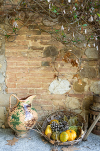 秋季背景。篮子与不同的南瓜, 缺点, 叶子和老式花瓶。庭院装饰。托斯卡纳意大利