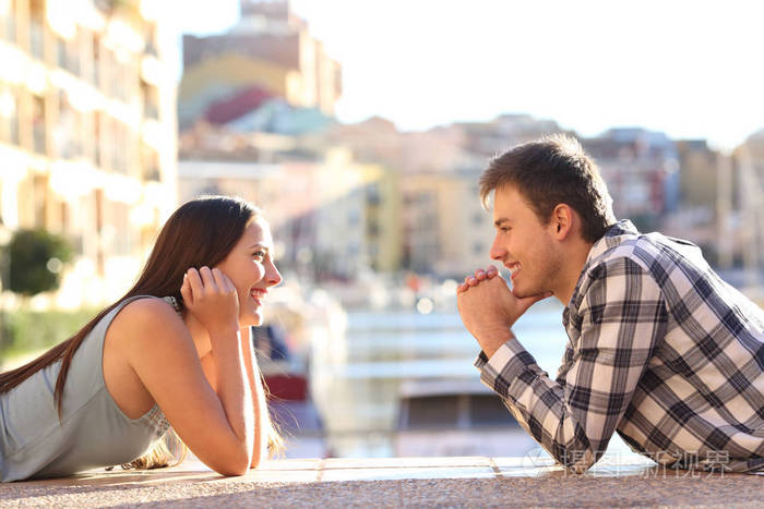 在海滨小镇阳光明媚的街道上两个快乐的青少年坠入爱河互相对视