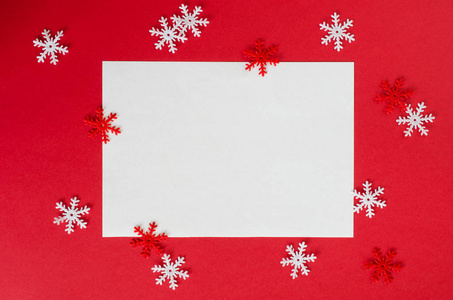 极简主义圣诞卡模型与装饰雪花红色。 空明信片。 圣诞节背景顶部视图与复制空间。