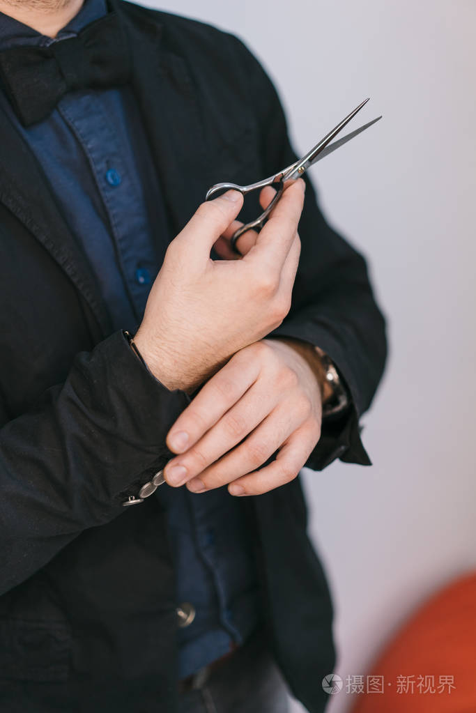 理发剪刀在穿黑色西装的人手中. ?