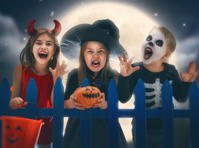 万圣节快乐的兄弟和两个姐妹.户外嘉年华服装的有趣孩子.