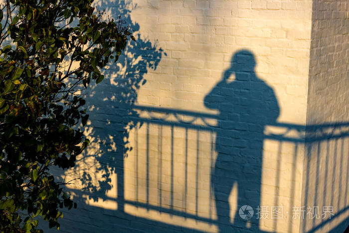 一个人在白色建筑墙上的影子