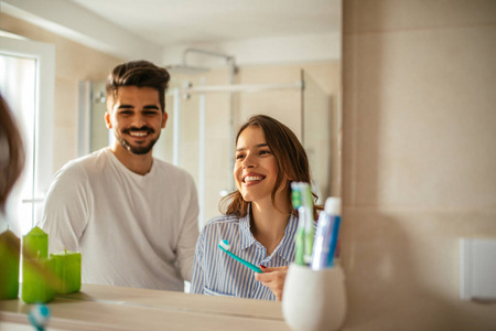 一对年轻夫妇在浴室刷牙的肖像。