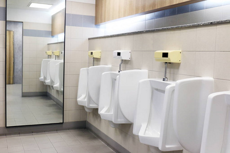 s bathroom, white ceramic urinals for men in toilet room