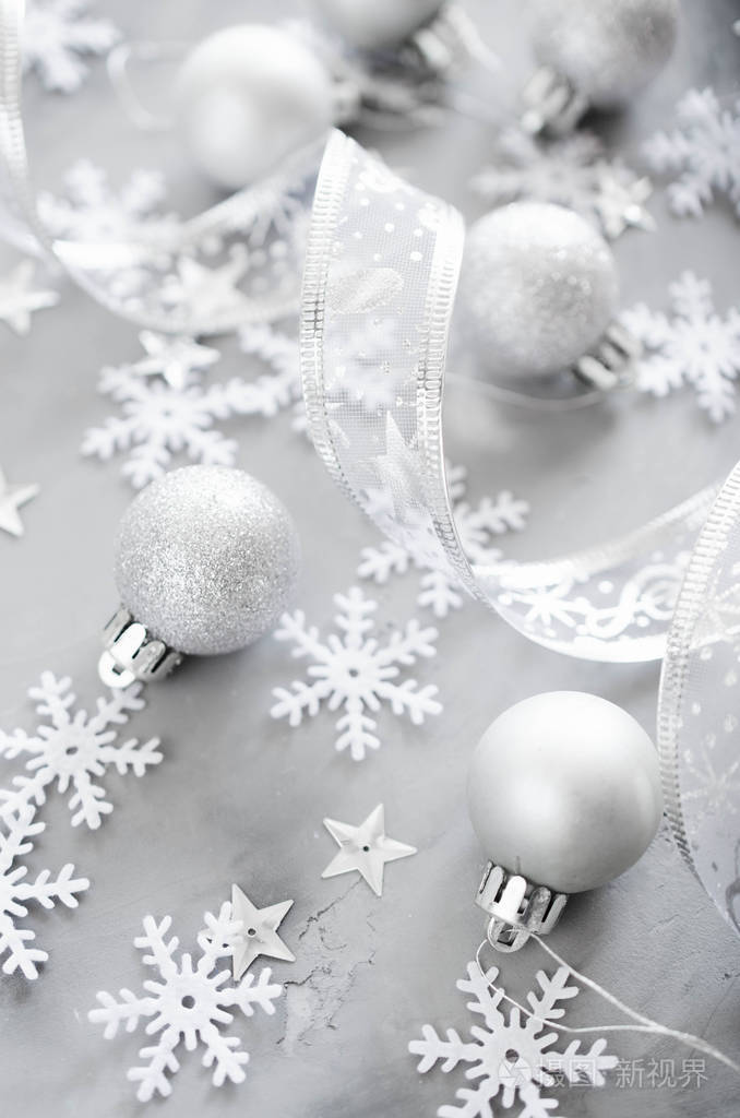 银色圣诞背景。 带有装饰球和雪花的卷曲丝带。 圣诞装饰品。