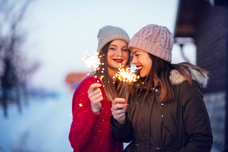 女人在户外用闪闪发光的棍子许愿的照片.照片