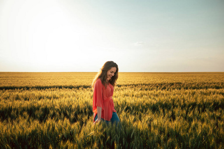 一个满意的年轻女人在田野里享受的肖像。