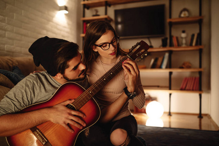 帅哥用吉他给他女朋友演奏一些音乐。