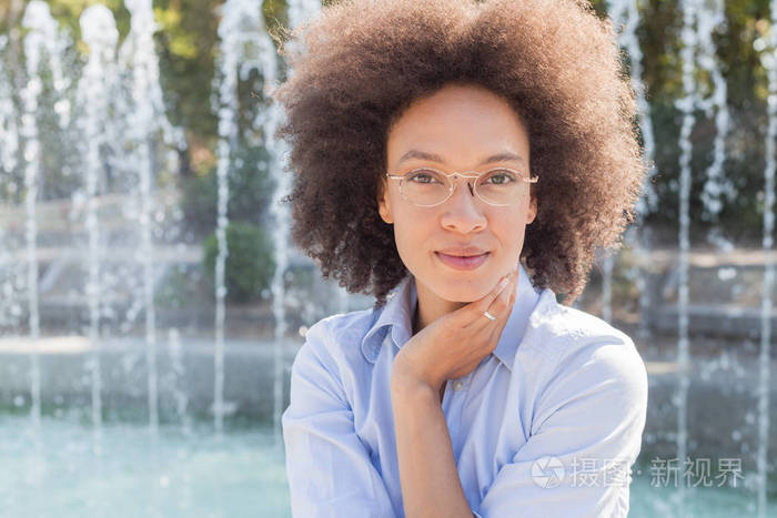裔美国人幸福的户外肖像,笑脸,发型,戴眼镜,休闲服装,深色皮肤的女性