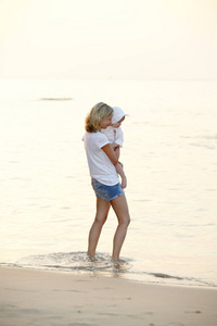 泰国海滩上和女儿玩耍的年轻女子