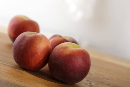 一堆新鲜的熟桃放在木桌上，特写