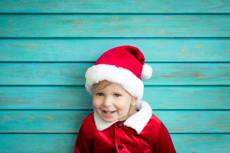 穿圣诞老人服装的儿童肖像。孩子在圣诞节开心。圣诞快乐概念
