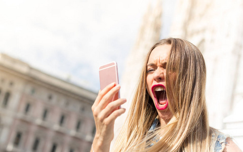 愤怒和沮丧的女人在手机上尖叫