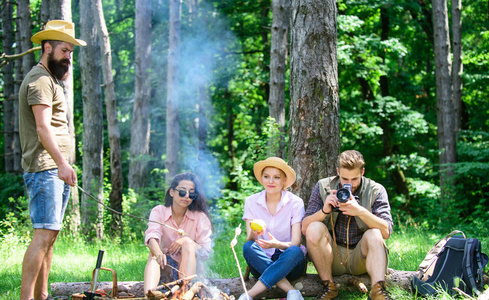 公司徒步旅行者放松在野餐森林背景。露营和徒步旅行。公司的朋友放松和有小吃野餐的自然背景。周末花很大的时间。休息一下吃点零食