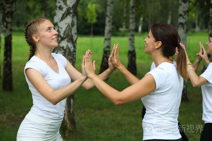 微笑的女人面对面地在公园练习