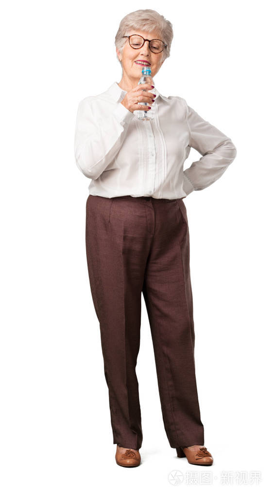 全身的老年妇女微笑着,满意地拿着一瓶冷水,记得水化对身体很重要