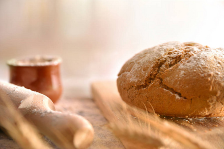 厨房里黑桌子上自制的面包面包，上面有捏合剂和面粉。 前面的风景。 水平组成部分