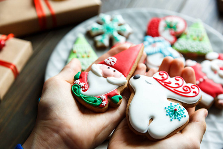 姜饼饼干圣诞节新年在孩子们手上的木桌上。 节日甜点美味饼干。 家庭庆典装饰概念