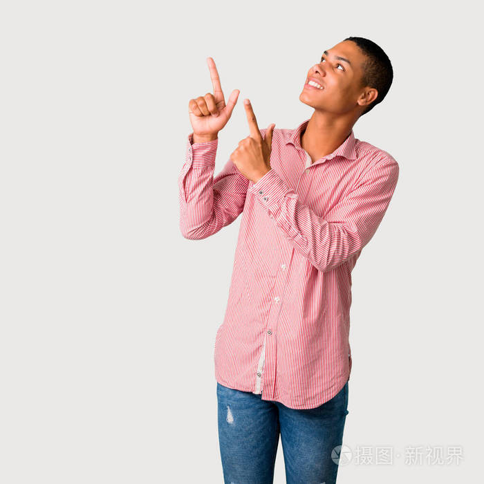 年轻的非裔美国人用食指指着一个好主意,抬头看灰色背景