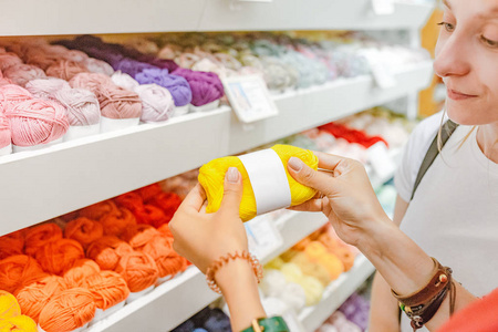 妇女选择纱线和羊毛球购买工艺店