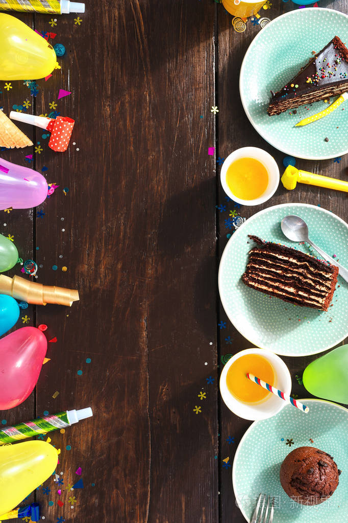 俯视儿童生日餐桌概念.巧克力蛋糕框架和棕色木制背景平躺装饰派对