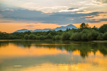 一个美丽的，五彩缤纷的日落景观与湖，山和森林。夏天山湖上自然的傍晚景色..塔特拉山在斯洛伐克，欧洲。